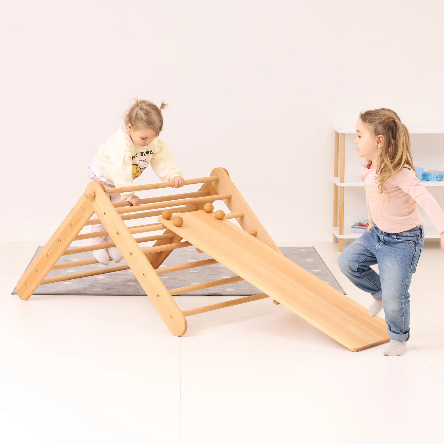 Two children playing on CLIMBIE Montessori climbing triangle and ramp set indoors