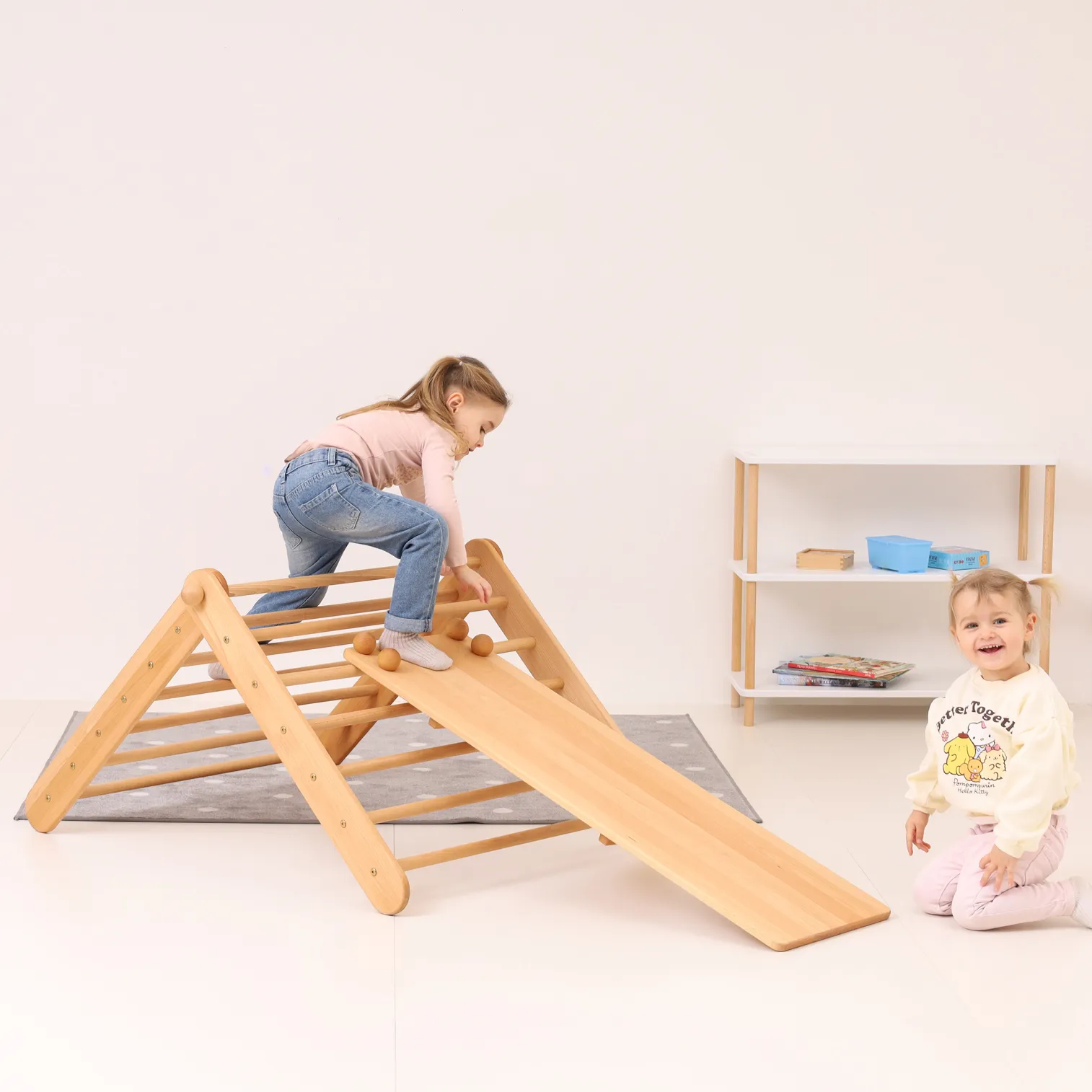 Two children playing on CLIMBIE Montessori climbing triangle and ramp set indoors