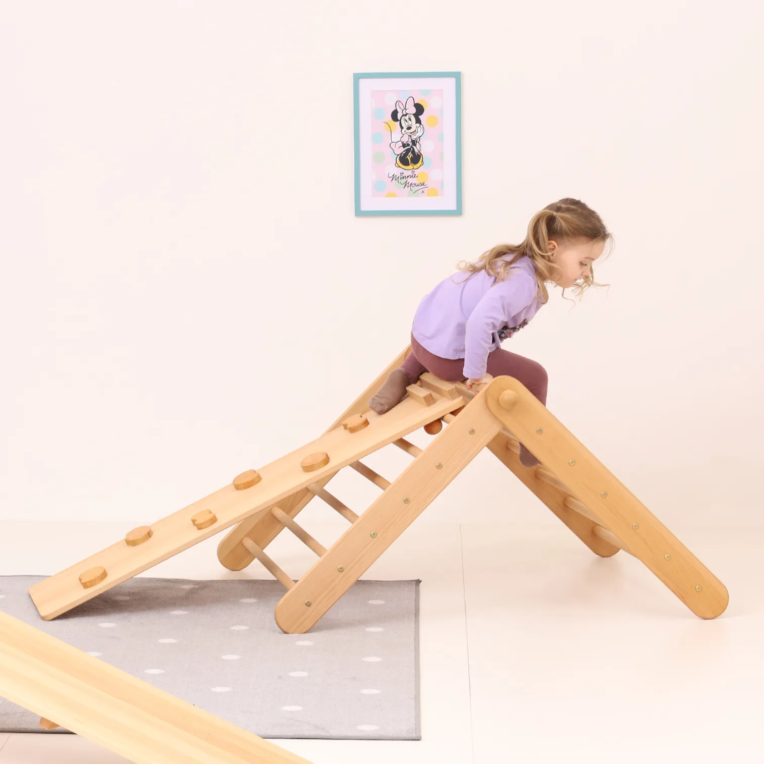 Toddler climbing on CLIMBIE Montessori wooden triangle in living room – indoor Pikler-style climbing frame